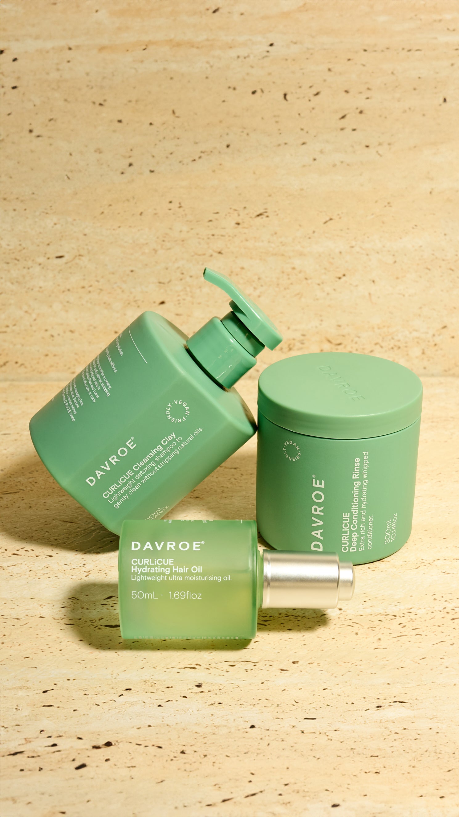 Three green Davroe hair care products on a wooden surface